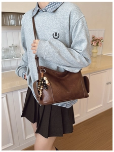 Nahaufnahme einer braunen Vintage-Leder-Tasche mit ethnischem Perlen-Quasten-Detail