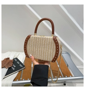 Detail of rainbow woven handbag with brown leather trim and golden metal rivet accents