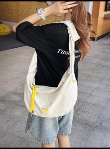 Detail of white checkered nylon crossbody bag with yellow zipper pull and logo