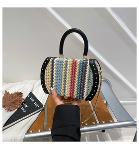 Detail of the colorful woven texture with gold studs and black leather trim on bag