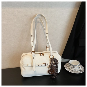 Detail of white leather underarm bag with metal eyelets and adjustable buckle straps