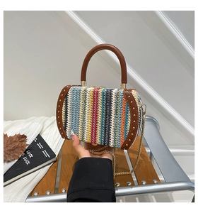 Detail of bohemian rainbow woven bag with brown leather trim and gold metal studs