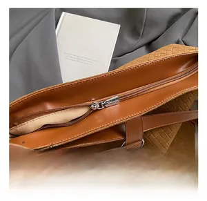 Detail shot of the brown woven tote bag zipper and premium light fabric interior lining