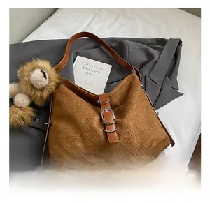 Close-up of brown woven hobo bag featuring premium texture and metallic buckle detail
