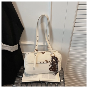 Close-up of a white vintage luxury handbag with adjustable strap on a suitcase
