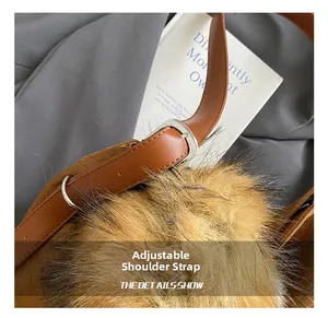 Detail of adjustable leather shoulder strap with silver buckle and brown faux fur charm