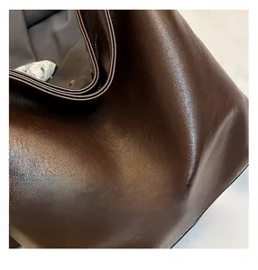 Detailed close-up of dark brown leather handbag showing fine stitching and craftsmanship