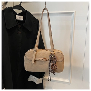Detailed macro view of beige retro pillow bag with long tassels and adjustable strap