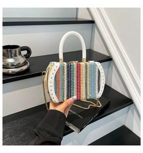 Detailed macro of rainbow woven box bag with white PU handle and gold chain strap