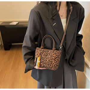 Dettaglio borsa shopper leopardata con perline decorative in legno e manico a nodo