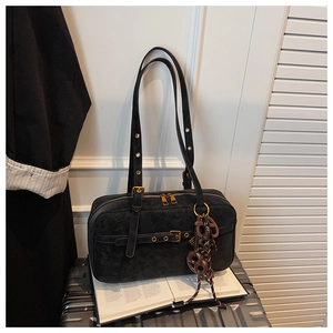 Detail of black suede shoulder bag with twin zippers and brown decorative cord pendant
