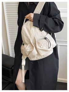 Outdoor sports backpack in cream white showing dual front pockets with drawstrings