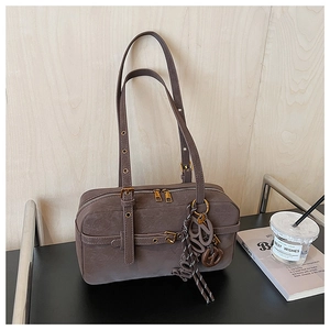 Detail of dark khaki retro leather pillow bag with dual zippers and logo pendant