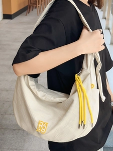 Minimalist cream waffle textured large crossbody bag with yellow tassel and RG logo