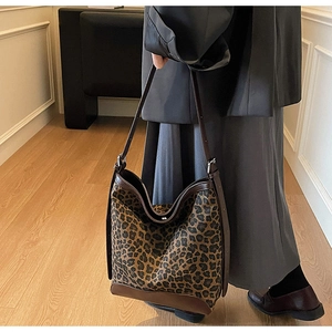 Detail of large leopard print bucket bag with premium leather trim and adjustable strap