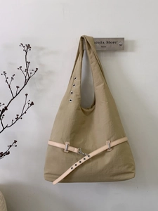 Minimalist khaki large tote bag with metallic eyelets and leather belt detail