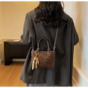 Vue détaillée de dos d'une femme portant un sac seau léopard avec pampille à perles