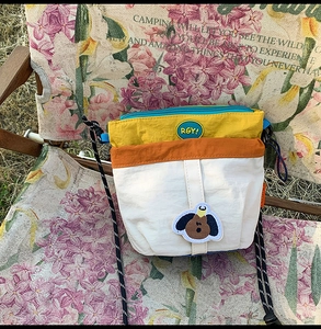 Dettaglio della borsa a tracolla in nylon colorato con patch a forma di cane