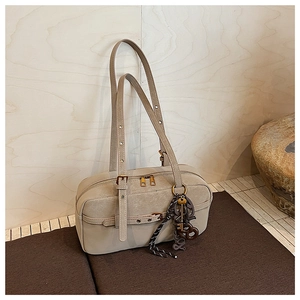 Detail of cream retro shoulder bag with woven pendant, key charm, and LOVE tag