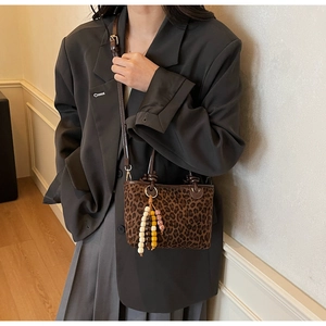 Détail du sac léopard avec pampille en perles de bois colorées et bandoulière fine
