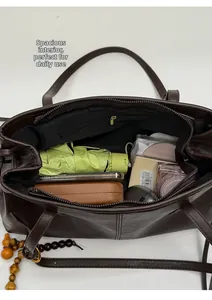 Macro view of the large capacity dark brown tote bag with various daily essentials inside
