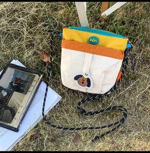 Dettaglio della borsa a tracolla in nylon color-block con ricamo e tracolla tessuta