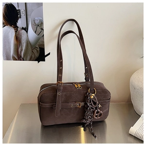 Macro shot of dark brown Boston bag with vintage leather texture and metallic buckle details