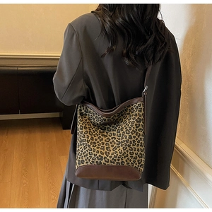 Detail showing high-capacity leopard print bucket bag with brown leather trim details