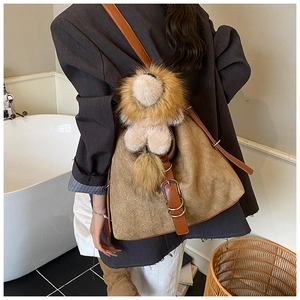Detail of vintage woven backpack featuring a lion plush charm and brown leather straps