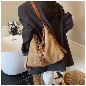 Detailed side view of khaki woven hobo bag with dark brown leather strap and metal buckle