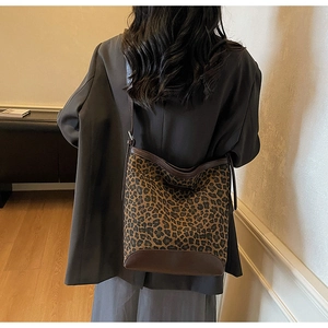 Rear view of a large leopard print bucket bag styled with a professional dark blazer