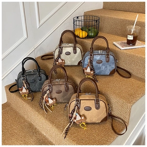 Boston style handbags in five colors displayed on steps with a cute bear charm