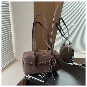 Close-up of brown vintage shoulder bag with dual zippers and golden metal hardware