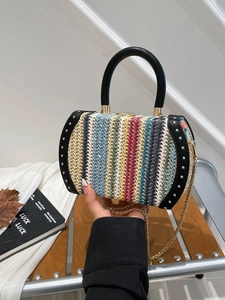 Rainbow woven bucket bag with gold chain strap and leather handle held by hand