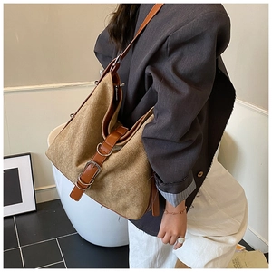 Close-up of a large khaki tote bag with woven texture and brown faux leather straps