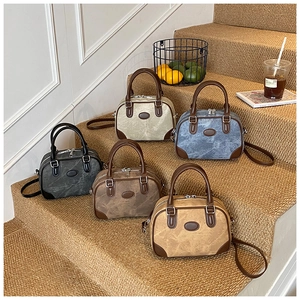 Detailed arrangement of vintage boston bags in five colors on a warm indoor staircase