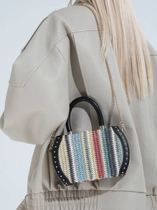 Rainbow woven chain handbag with colorful stripes and gold stud accents on a model
