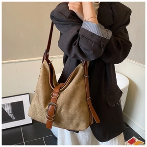 Detail of hobo bucket bag with dark brown leather strap and silver metal buckle hardware
