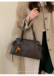 Detail of vintage chocolate brown tote bag with wooden bead charm and side drawstring