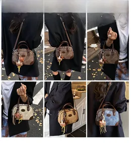 Detail of mini barrel bag showing contrast stitching, teddy bear charm and strap options