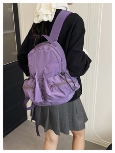 Outdoor leisure backpack for students shown as a model wearing the purple waterproof bag