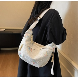 Detail of white canvas bag with multi-color butterfly embroidery and texture