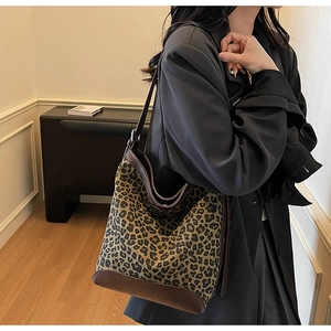 Close-up of leopard print bucket bag featuring premium dark brown leather trim and strap