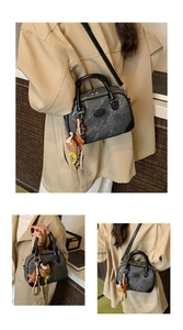 Detailed views of a dark grey marble pattern handbag with black leather trim and star charm