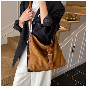 Detail of caramel brown woven hobo bag with adjustable leather strap and metal buckle