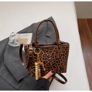 Dettaglio della borsa a secchiello leopardata con ciondolo in perline di legno etnico