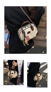 Detail of beige canvas and brown leather boston bag with cute bear and star charms
