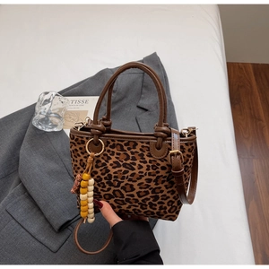 Dettaglio della borsa a secchiello leopardata con ciondolo in legno e manico in pelle