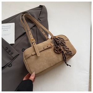 Detailed macro view of khaki leather underarm bag featuring crackle texture and metal buckle