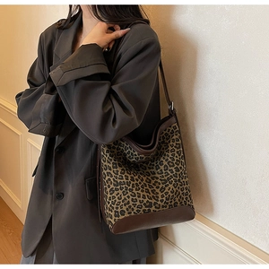 Detail of leopard print bucket bag with brown leather trim and spacious canvas interior